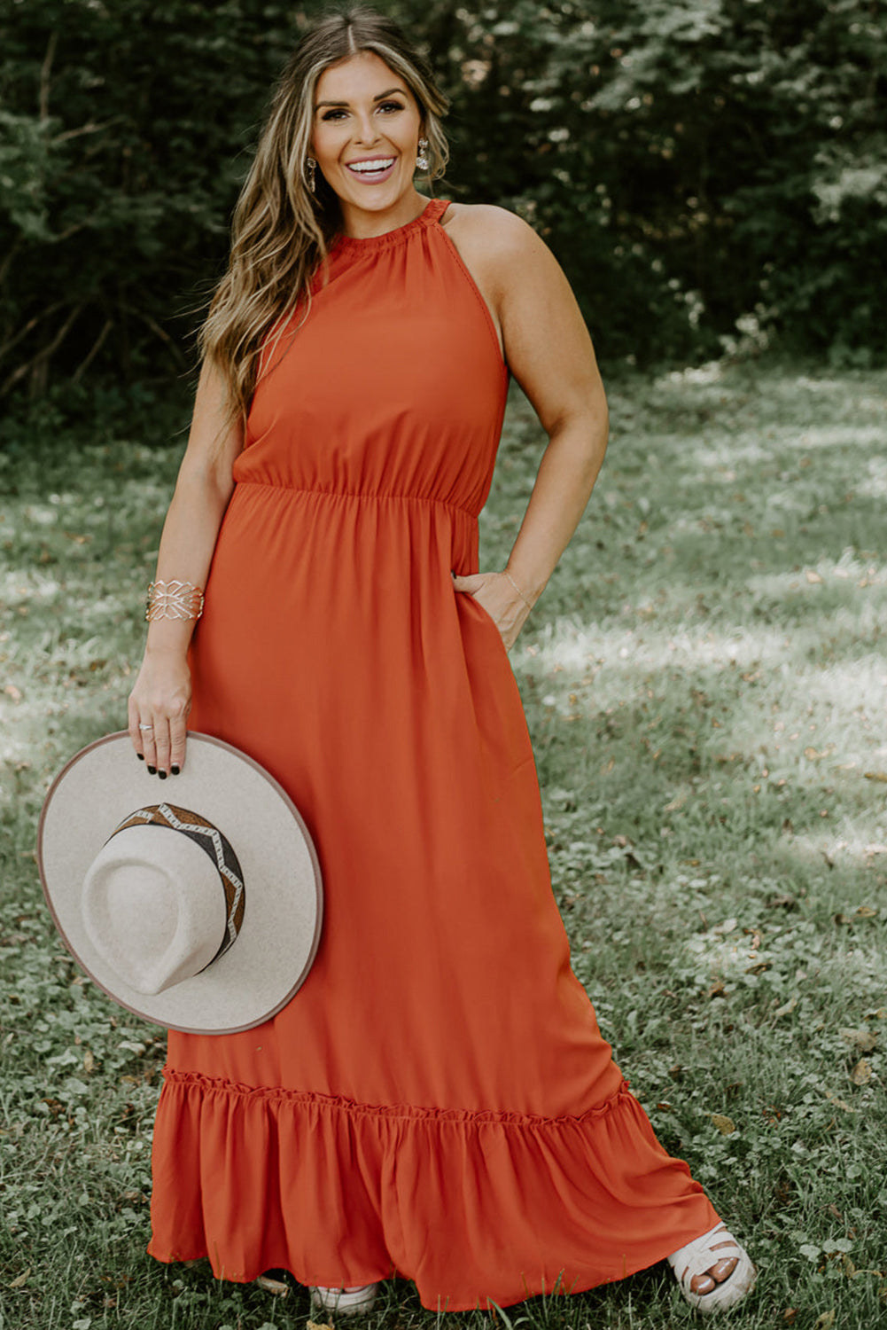 Plus size fashionista stunningly showcasing a sleeveless long dress featuring an elegant ruffled hem, perfect for summertime outings and special celebrations.