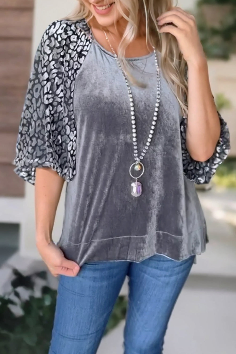 This medium grey velvet blouse features a bold leopard print splicing and lantern sleeves for a fashionable statement look.