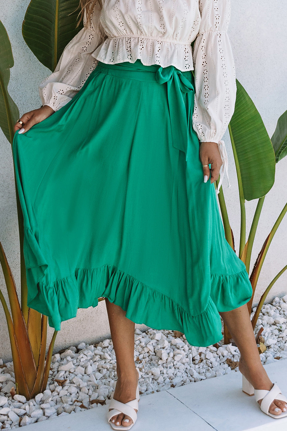 A stunning green high-waisted maxi skirt featuring an asymmetrical flounce, belted waist, and a chic look to complete any outfit.