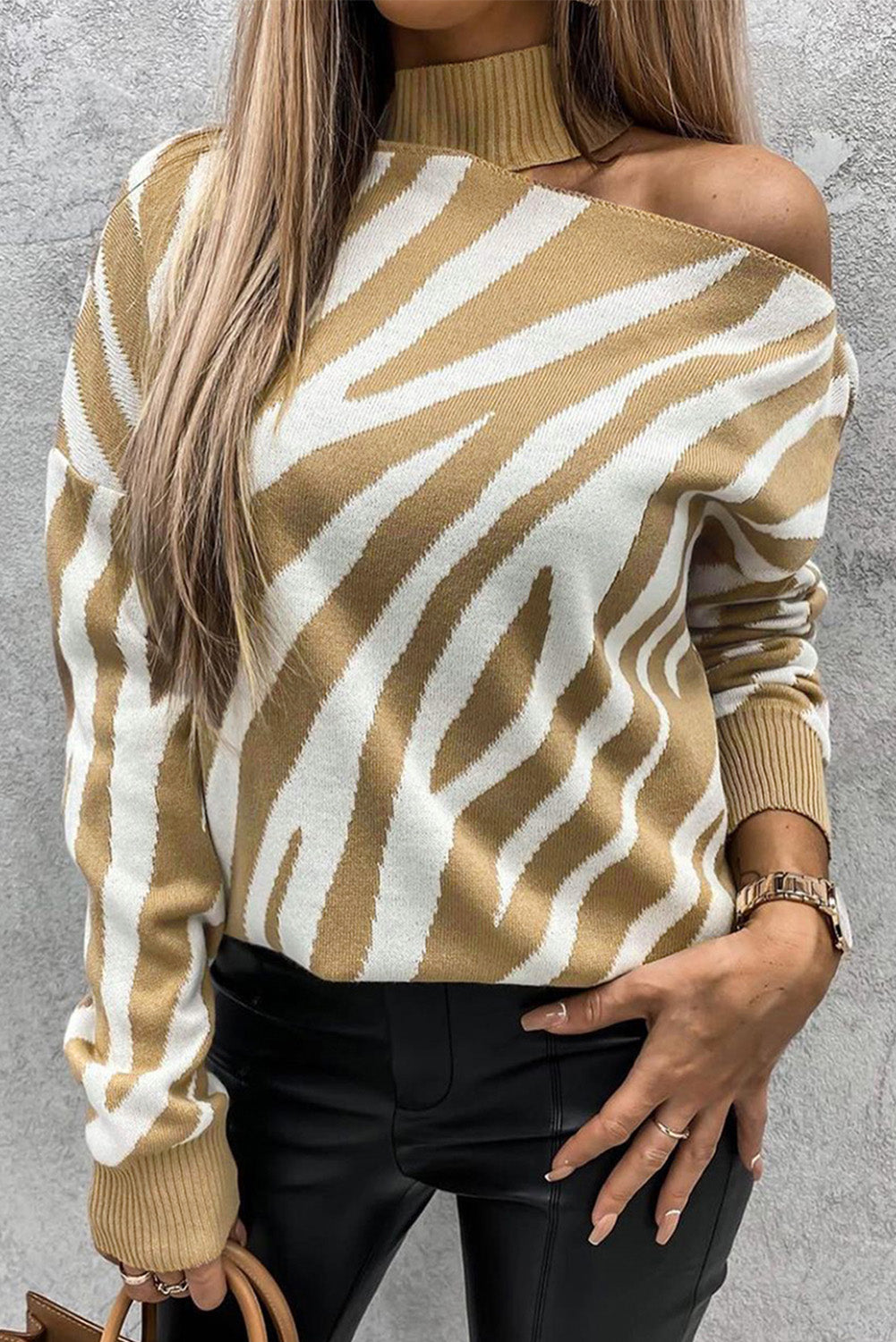 A khaki coloured zebra print sweater with a mock neck and cold shoulder.
