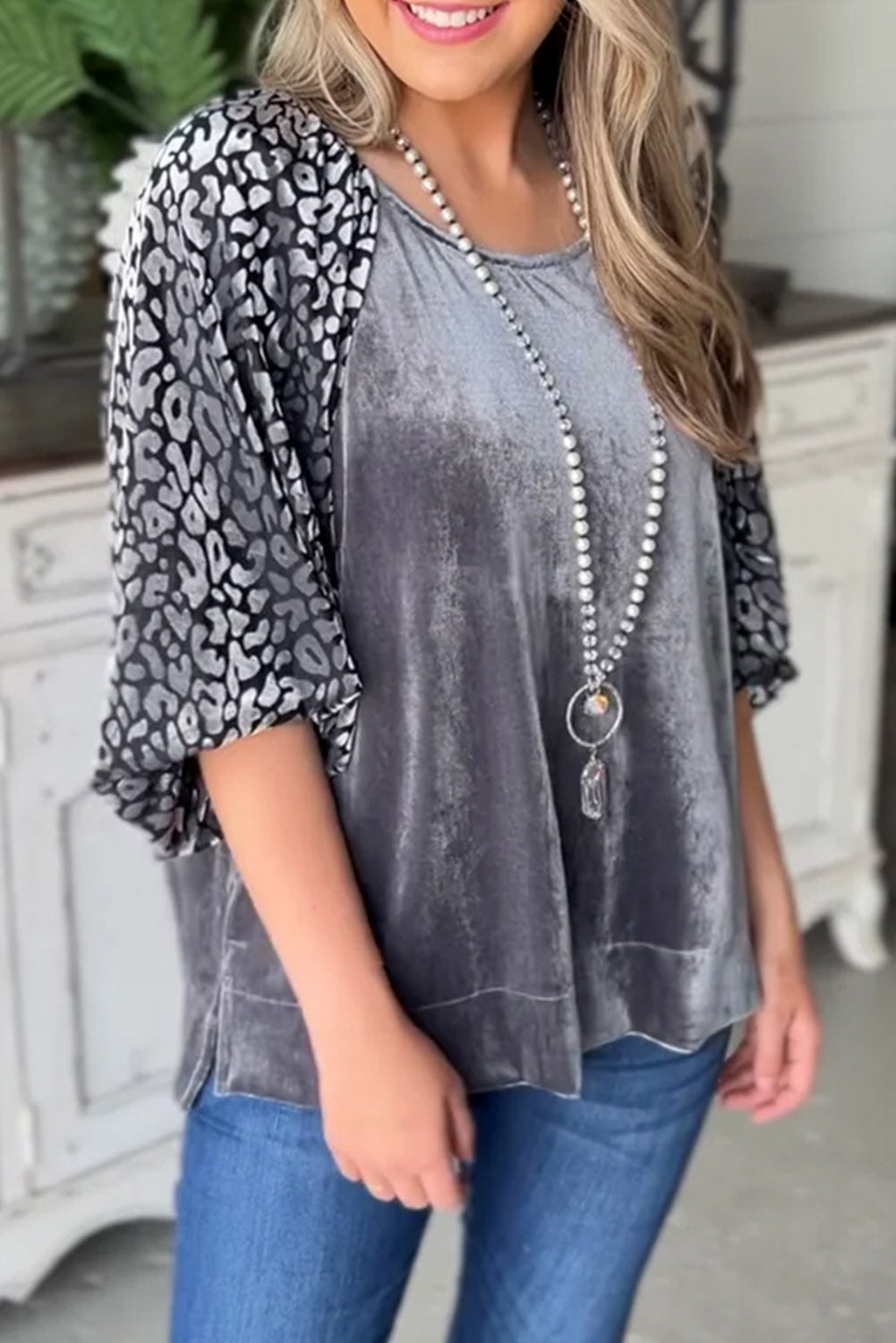 This medium grey velvet blouse features a bold leopard print splicing and lantern sleeves for a fashionable statement look.