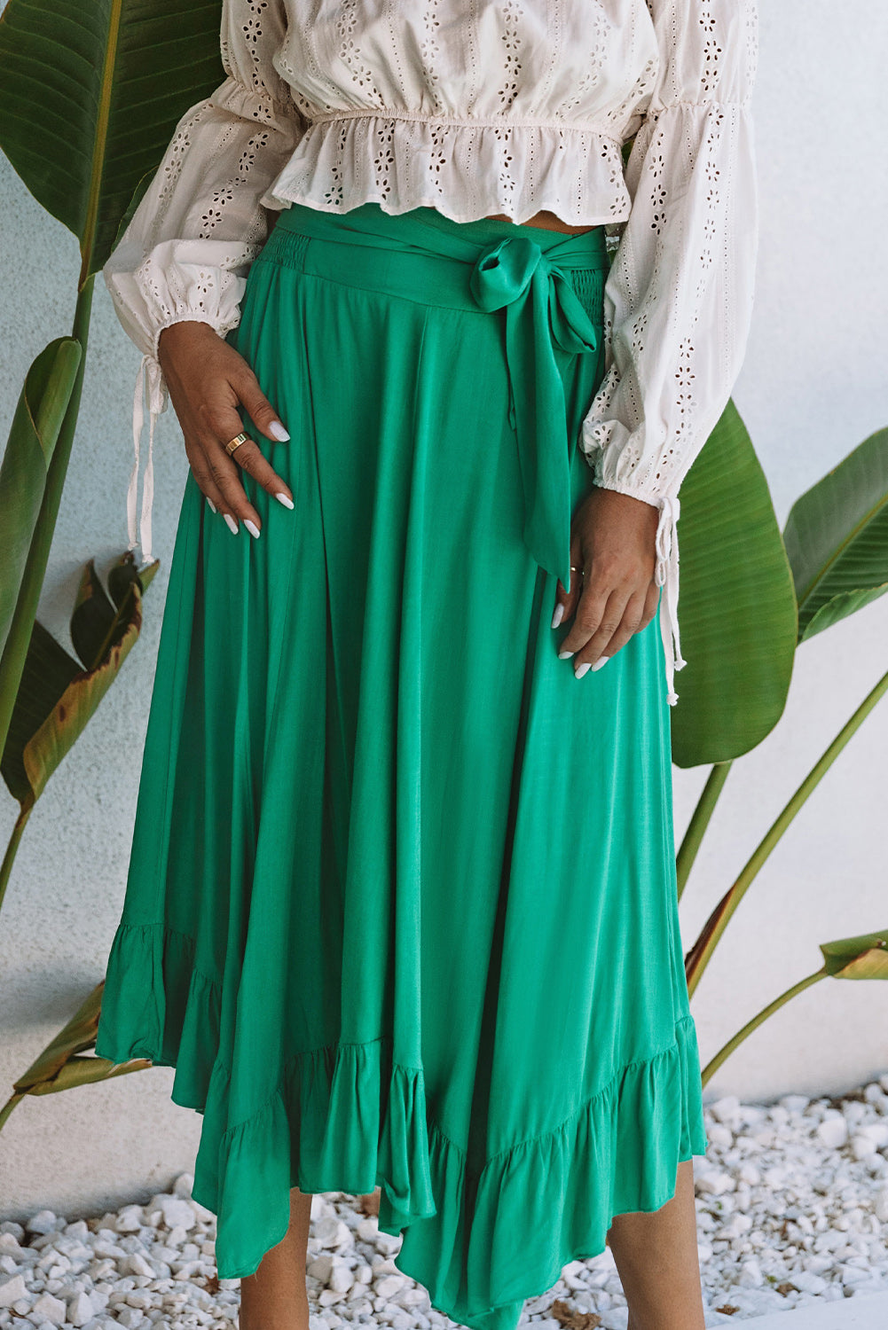 A stunning green high-waisted maxi skirt featuring an asymmetrical flounce, belted waist, and a chic look to complete any outfit.