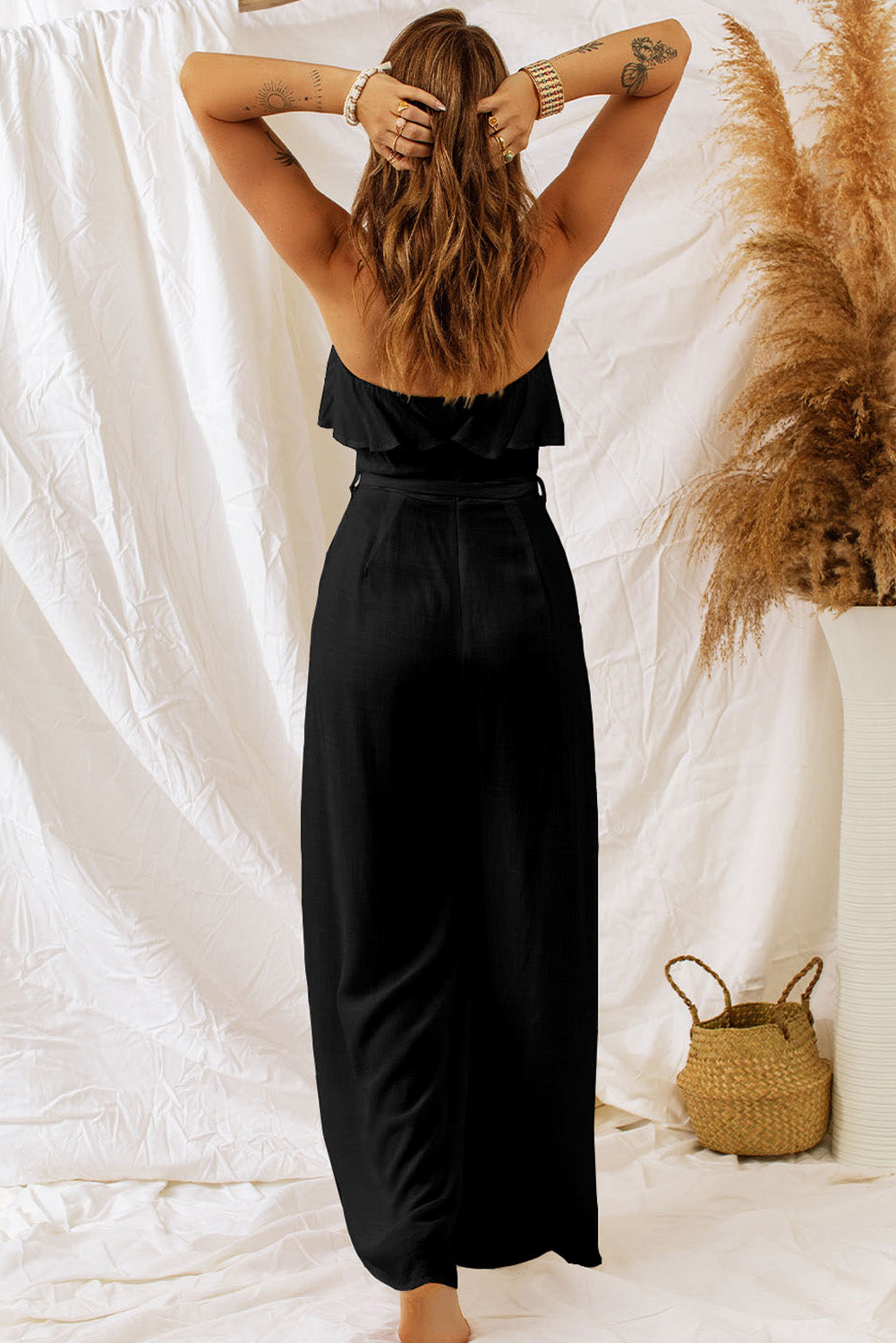 Sexy strapless bandeau silhouette with ruffle overlay, attached belt, and wide leg bottoms. Made with viscose and linen fabric blend.