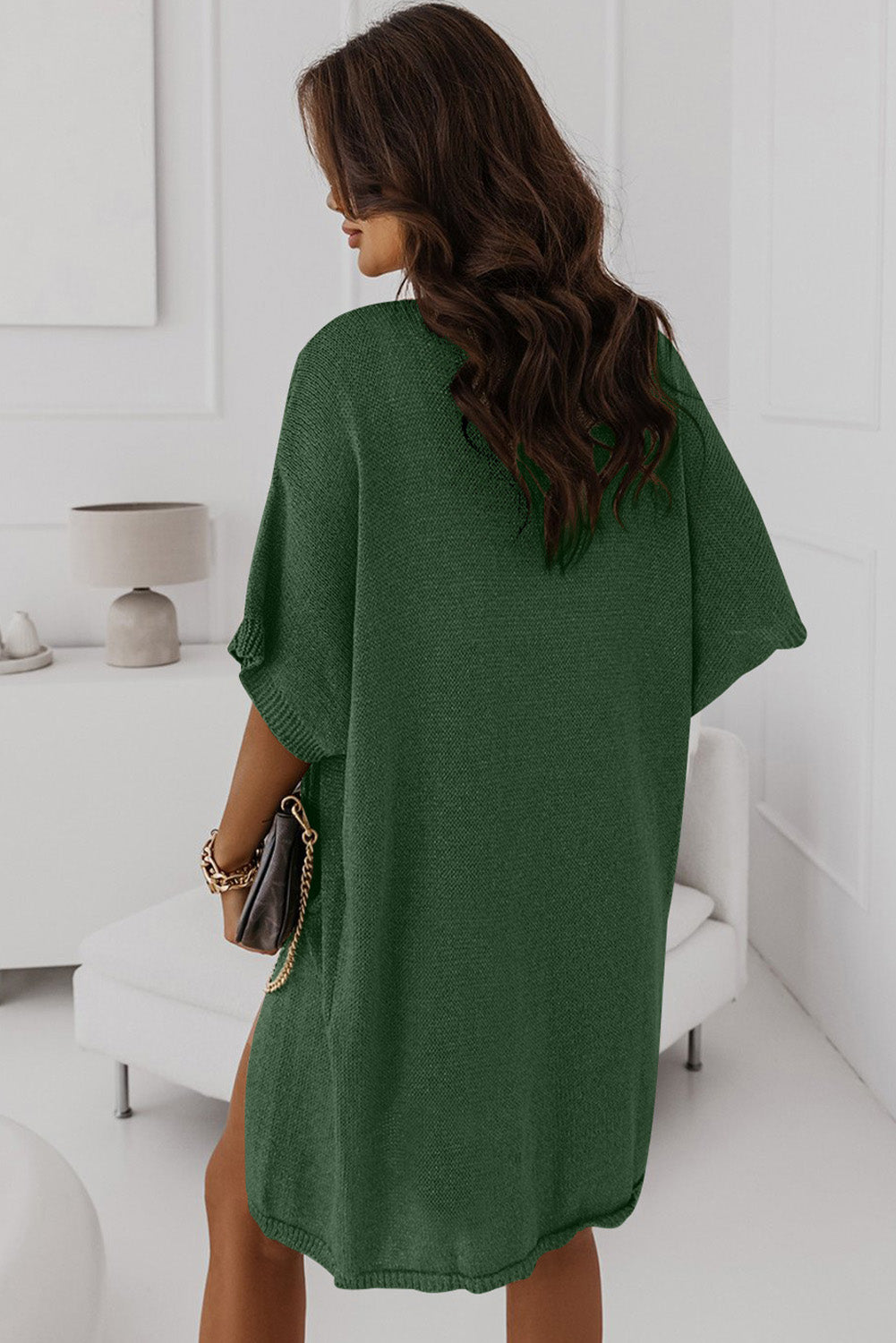 A green dolman half sleeve cardigan with two pockets in a relaxed, long fit.