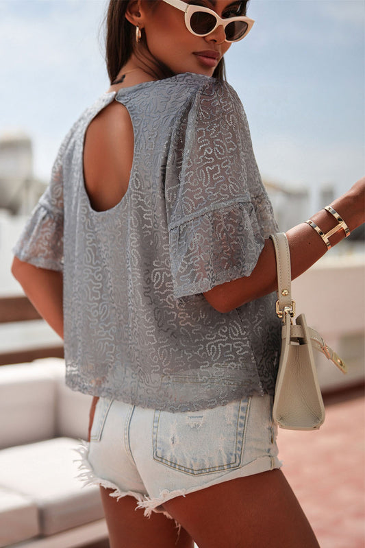 A grey blouse decorated with shimmering sequins and ruffled sleeves, to craft a fashionable and glamorous look for day or night.