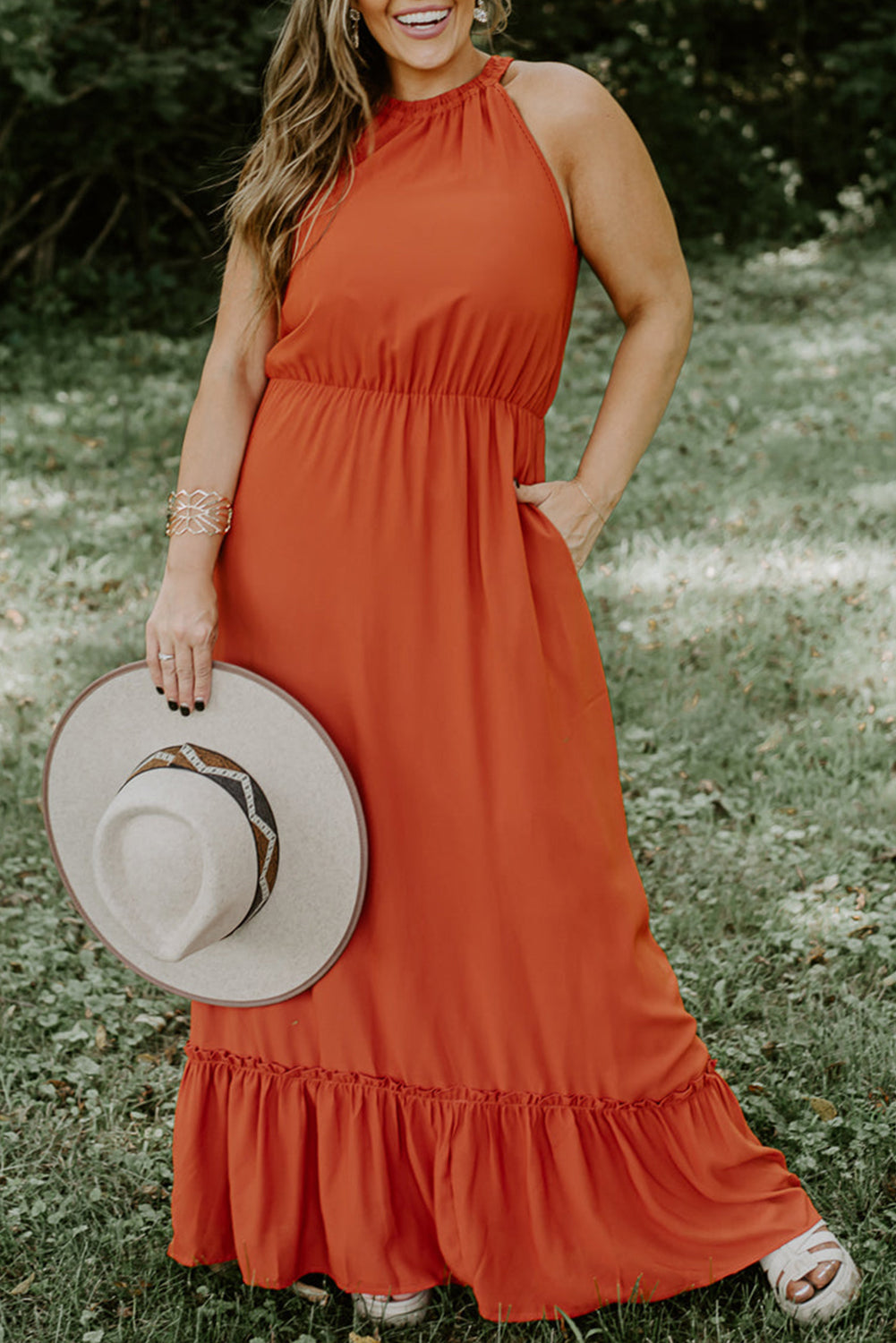 Plus size fashionista stunningly showcasing a sleeveless long dress featuring an elegant ruffled hem, perfect for summertime outings and special celebrations.